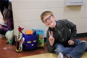 Boy with Pete the Cat book and decorated pumpkin.